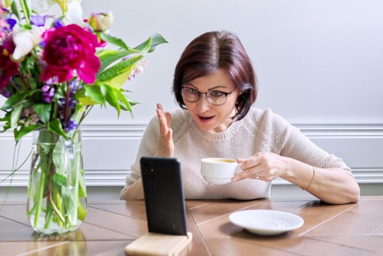 Person streaming Aunt Tea Podcast on a laptop, watching episodes for free on platforms like YouTube, Spotify, and Apple Podcasts.