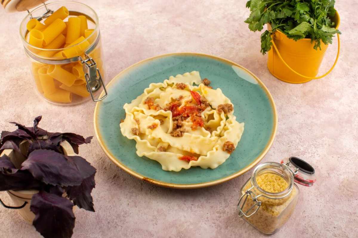A dish of old-fashioned baked macaroni and cheese with creamy pasta, a golden, crispy breadcrumb topping, served in a casserole dish on a wooden table.