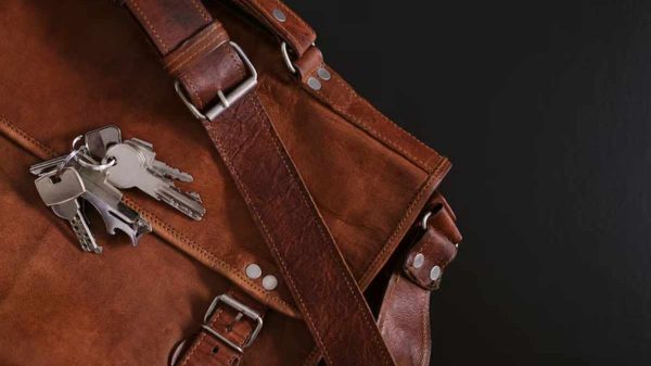 "Person wiping leather furniture with a premium leather cleaning wipe."